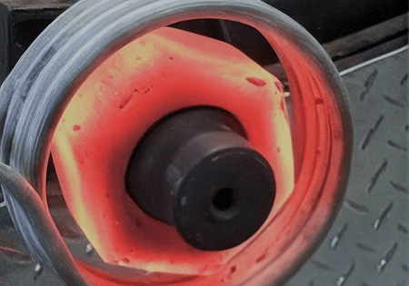 Glowing red-hot metal ring on mandrel